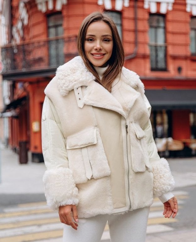 Pretty woman wearing a white fur bomber jacket