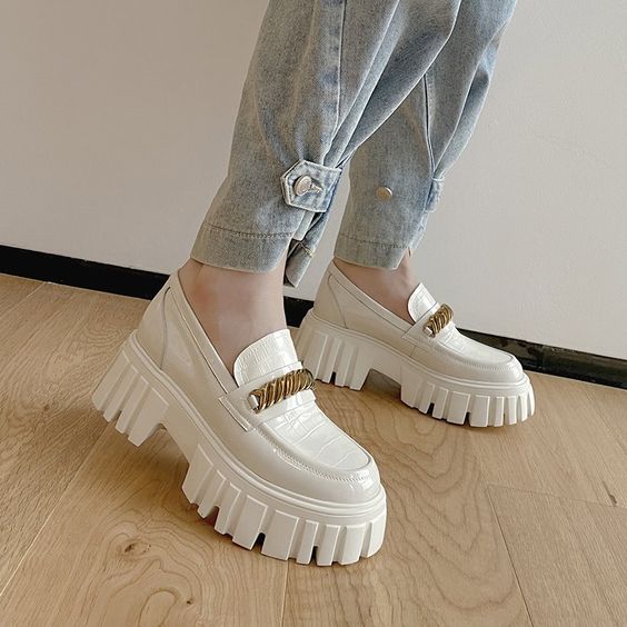 Beige chunky loafers with golden bits worn with jeans