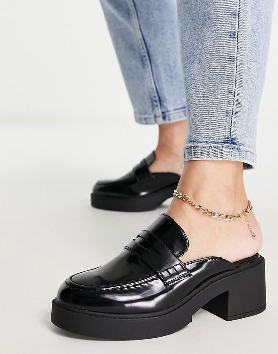 Black glossy loafers worn with an ankle strap