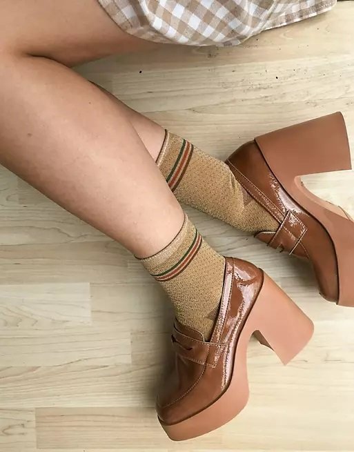 High-heeled women's loafers in tawny color worn with socks