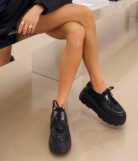 Pretty black patent loafers worn by a woman with a dress