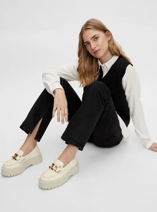 Beige wedge loafers worn with a shirt and pants