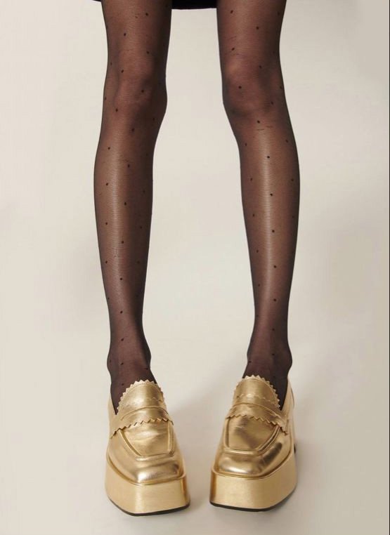 Gold wedge loafers worn with patterned tights