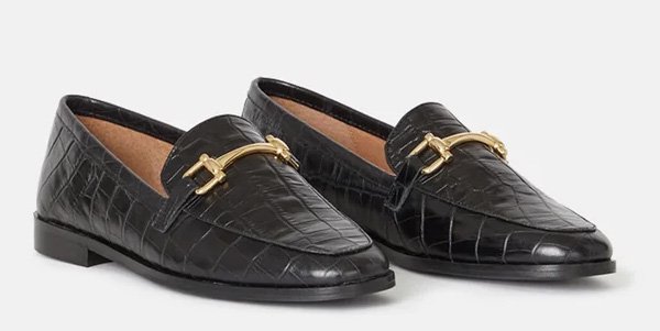 Black closed loafers with crocodile patterns and a golden chain in front