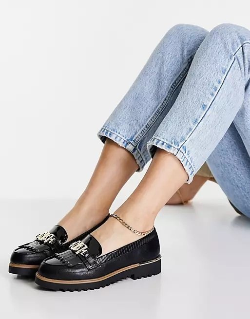 Black chunky loafers with logo worn with a pair of jeans