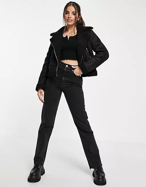 Woman in all black look with a short suede aviator jacket