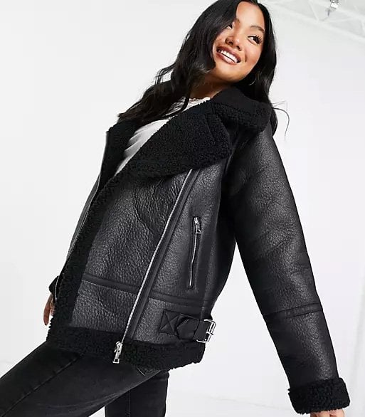 Black aviator jacket worn by a brunette woman