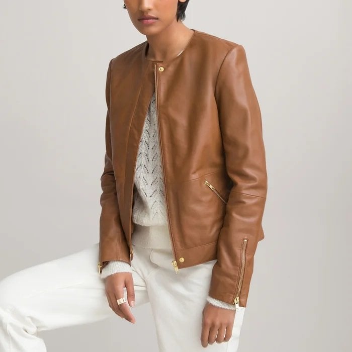 Collarless leather jacket worn by a woman with white bottoms