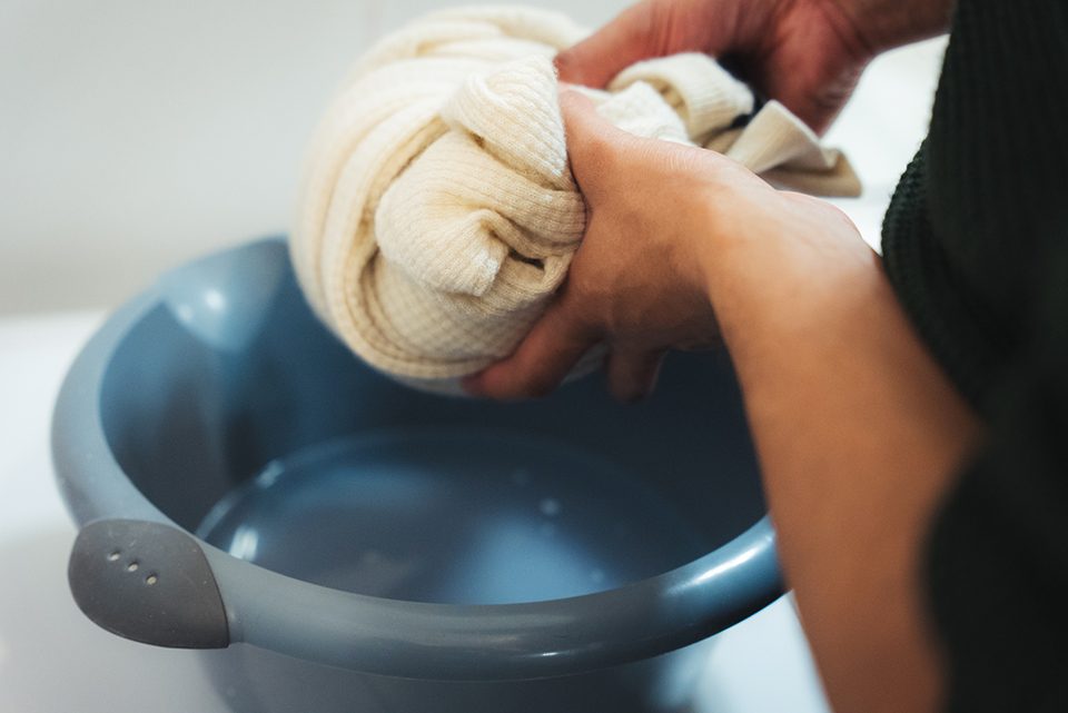 a person washing a cashmere sweater by hand