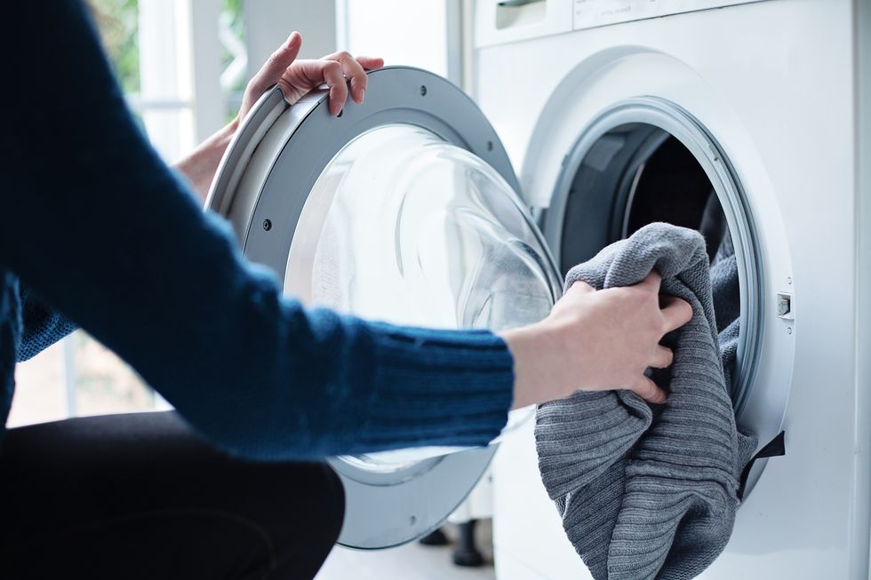 a person washing a cashmere sweater in the machine