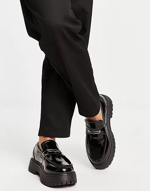 Black faux leather chunky loafers worn with baggy black pants