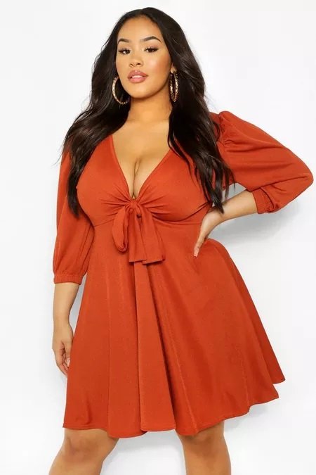 Stunning curvy woman wearing a cocktail dress below the knees.