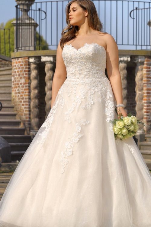 Simple bustier wedding dress worn by a curvy bride