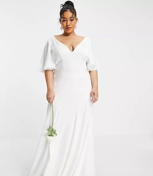 Curvy woman wearing a white empire wedding dress