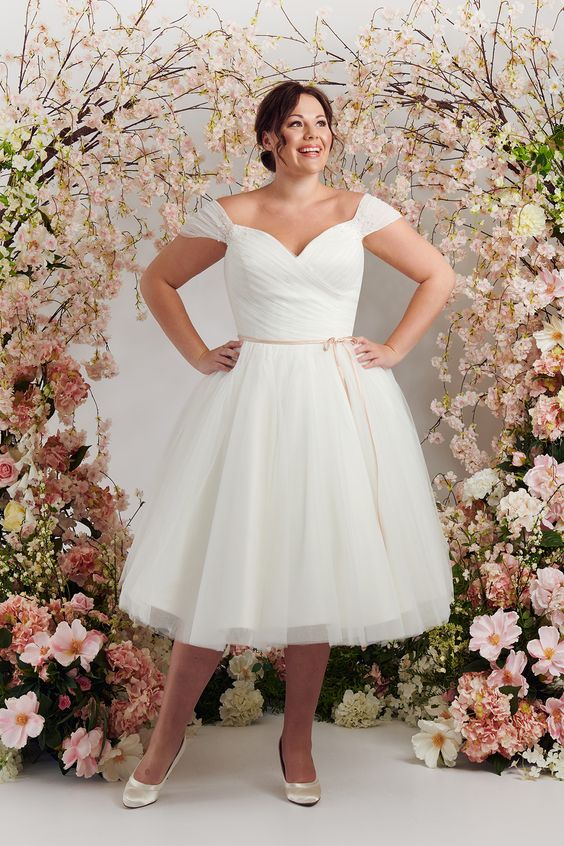 Curvy bride wearing a short off-shoulder wedding dress