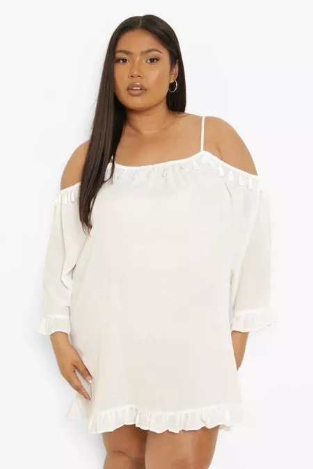 Curvy woman wearing a white straight dress with off-shoulder sleeves