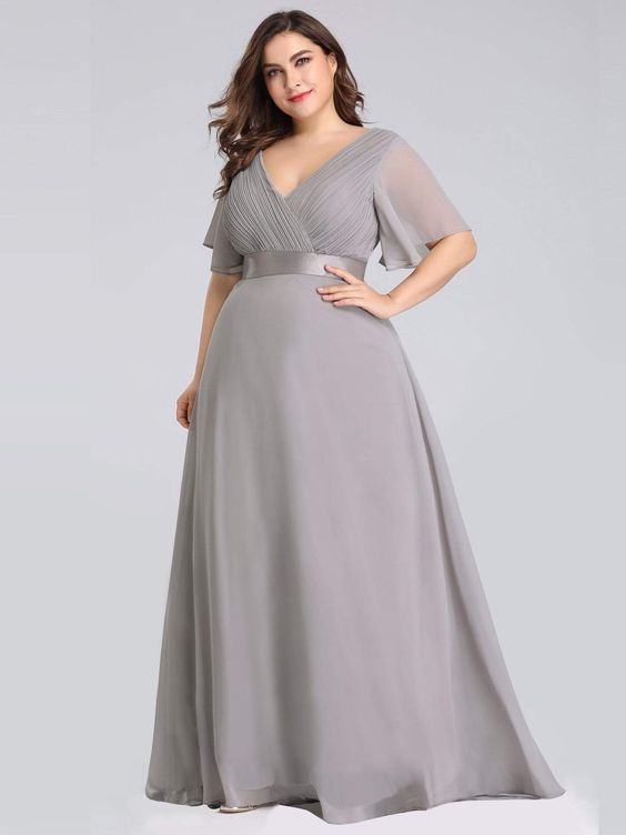 Curvy woman wearing a long gray empire dress