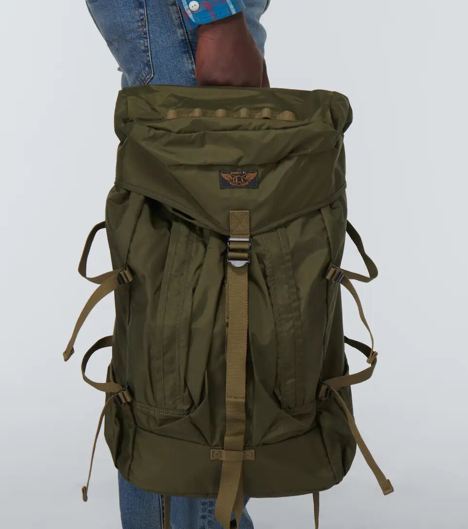 Man holding a khaki hiking backpack