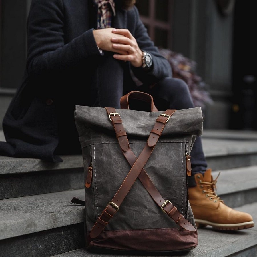 Vintage backpack for men worn with a pair of jeans and brown boots