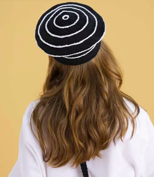 Brown-haired woman wearing a beret from the brand Phildar 