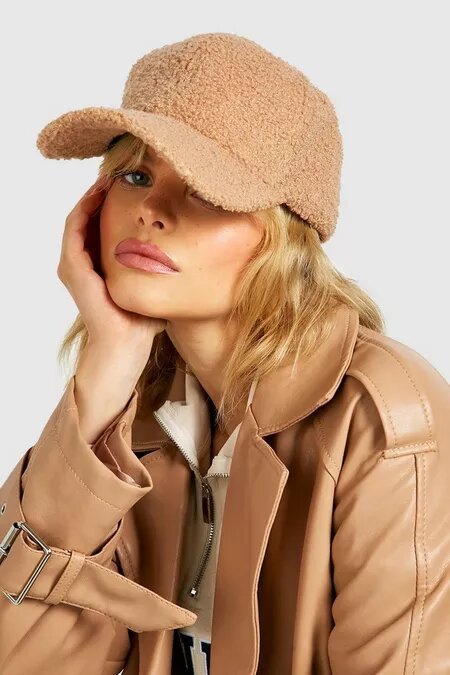 Woman wearing a nude fleece cap from Boohoo