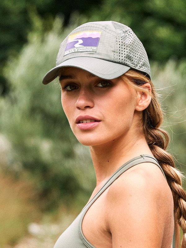 Woman wearing a green trucker cap from the brand Roxy