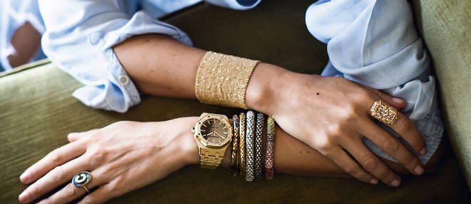 woman with light skin wearing a golden watch with bracelets