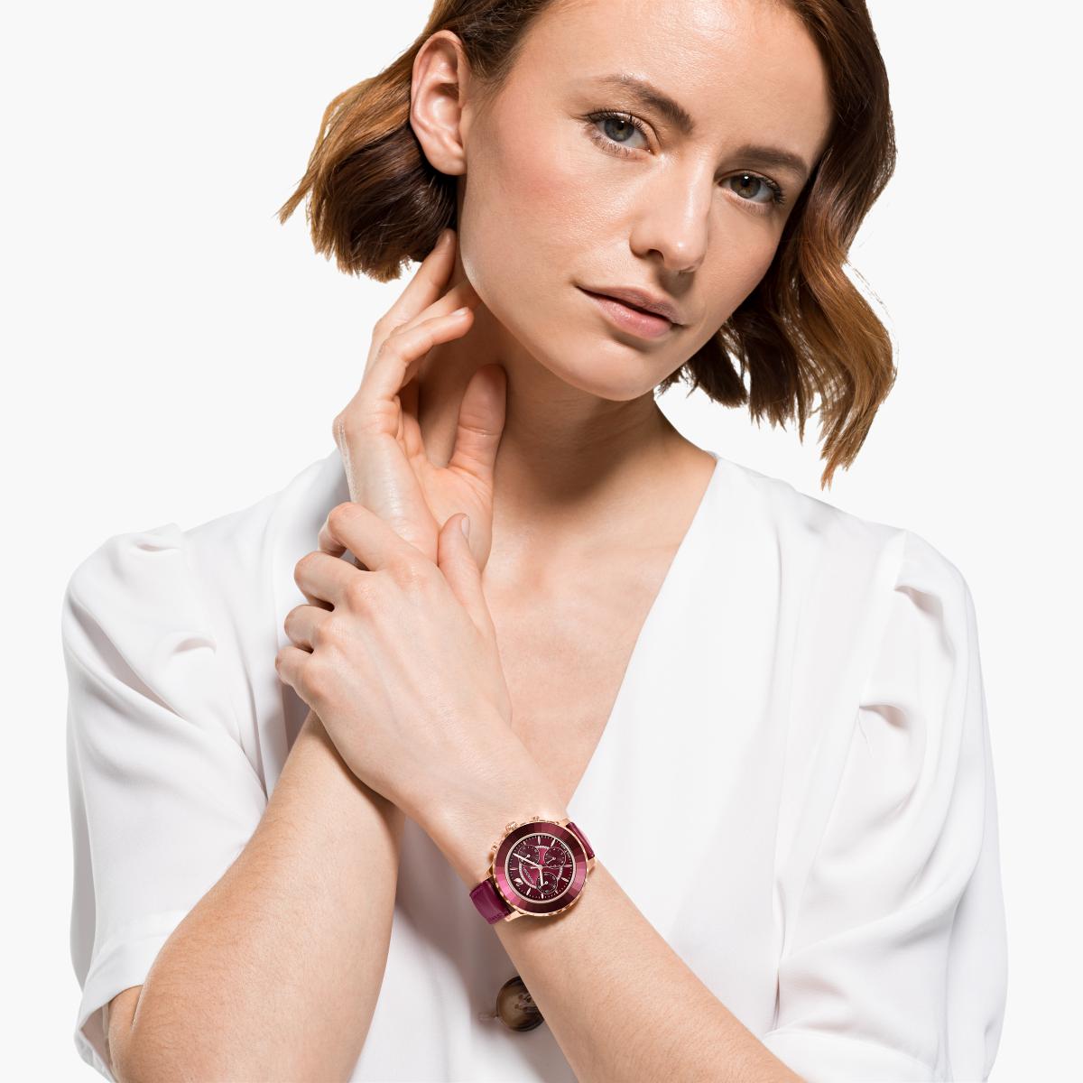 Woman wearing the burgundy chronograph watch from Swarovski