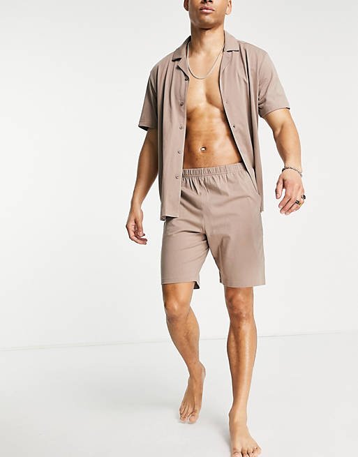 Man wearing a pajama set with shirt and shorts from Asos Design