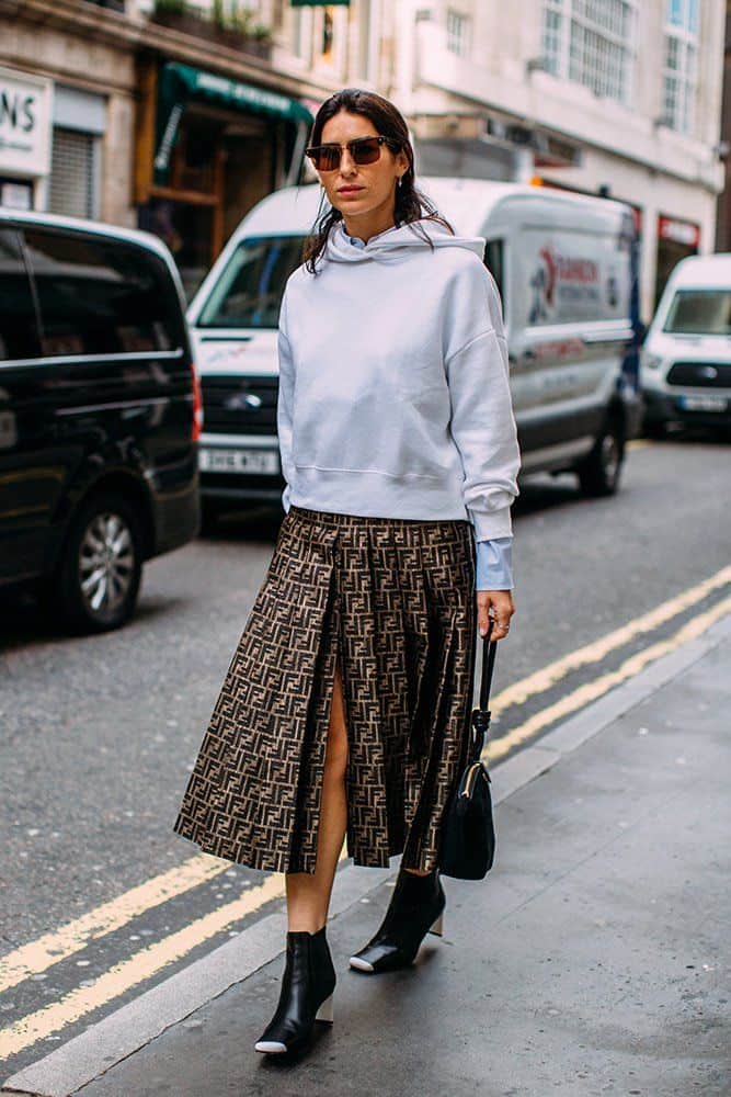 Woman wearing an oversized sweatshirt with a dress