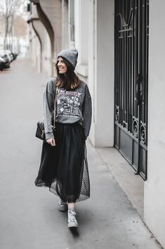 Woman wearing a gray oversized sweatshirt with a black tulle skirt