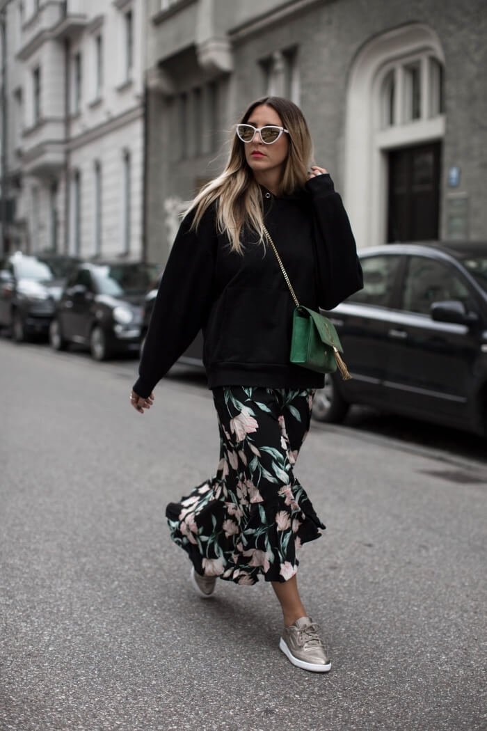 Woman wearing an oversized sweatshirt with a flowing dress