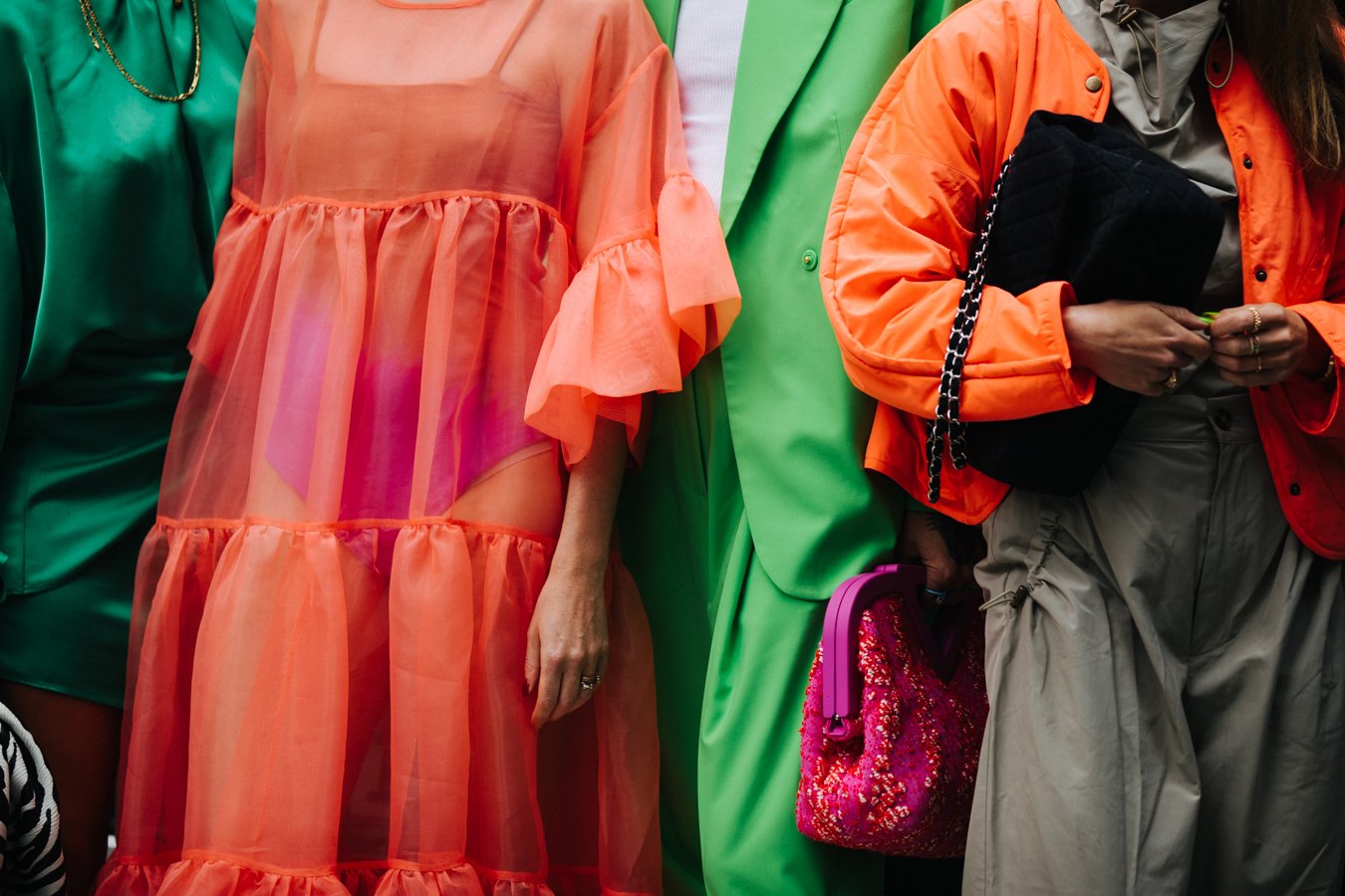 Photograph of several women in colorful outfits in front of a fashion week