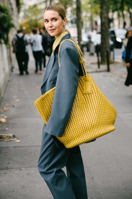 A woman carrying a large yellow tote