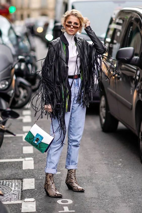 woman on the street wearing a spring look with a fringed jacket