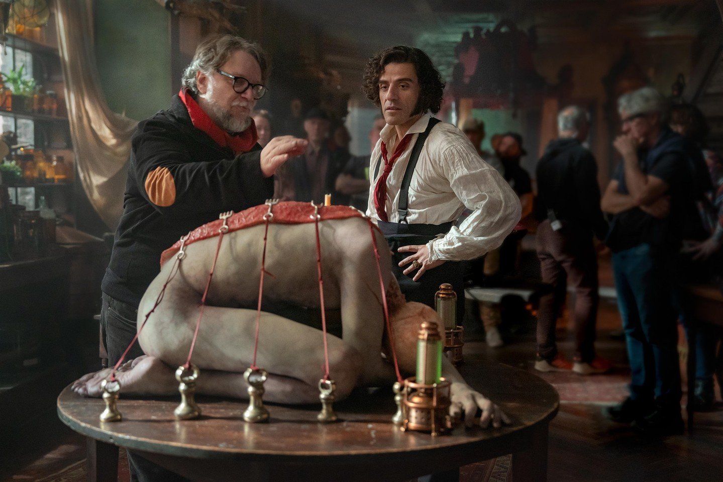 Behind the scenes photo of Frankenstein Guillermo del Toro and Oscar Isaac with puppet